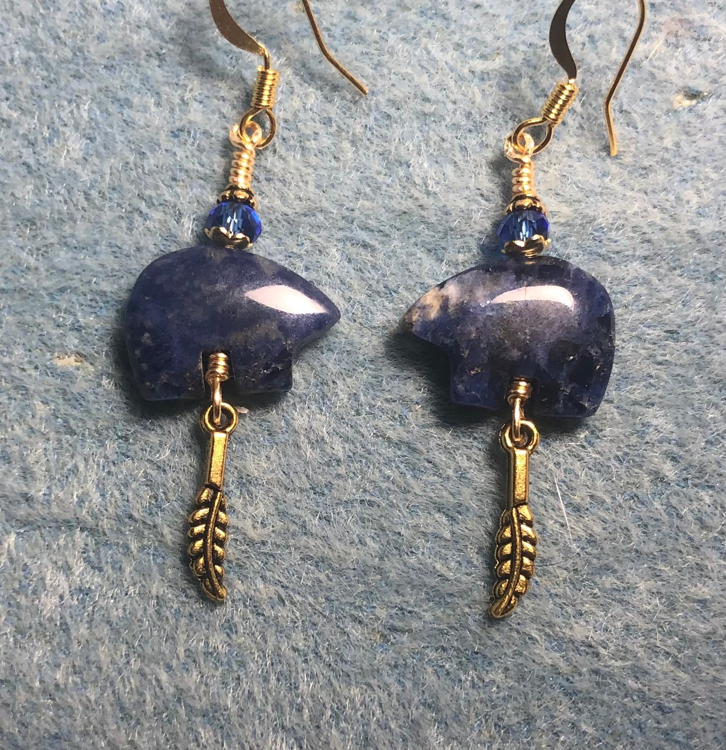 Blue dumortierite gemstone Zuni bear fetish bead earrings adorned with blue crystal beads and tiny gold feather charms.