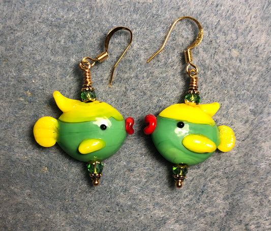 Green and yellow lamp work fish bead earrings adorned with green Chinese crystal beads.