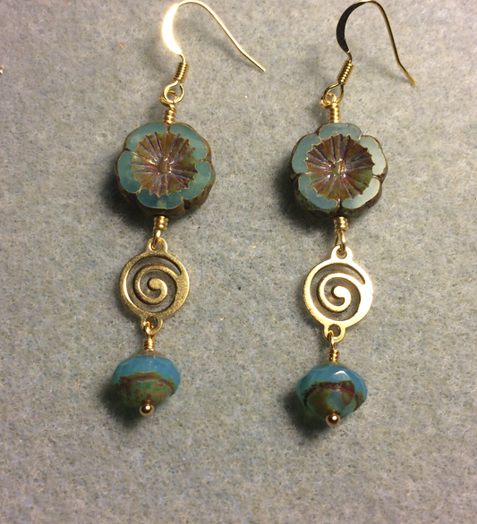 Turquoise green Czech glass pansy bead earrings adorned with gold swirly connectors and turquoise green Czech glass Saturn beads.