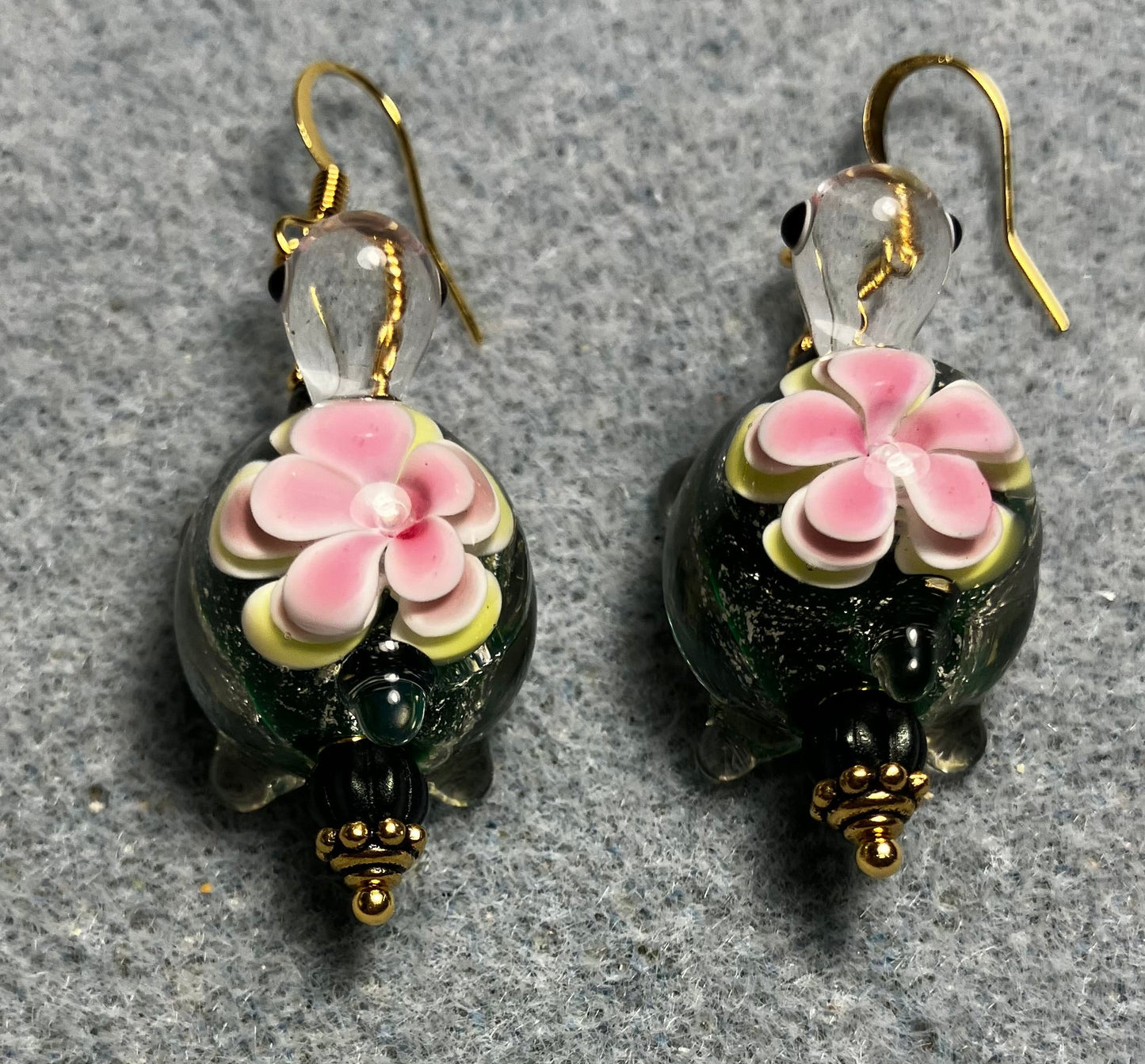 Large dark green and pink lamp work turtle bead earrings adorned with dark green Czech glass beads.