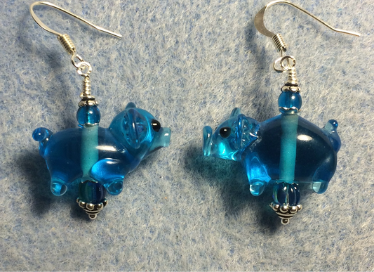 Translucent turquoise lamp work pig bead earrings adorned with turquoise Czech glass beads.