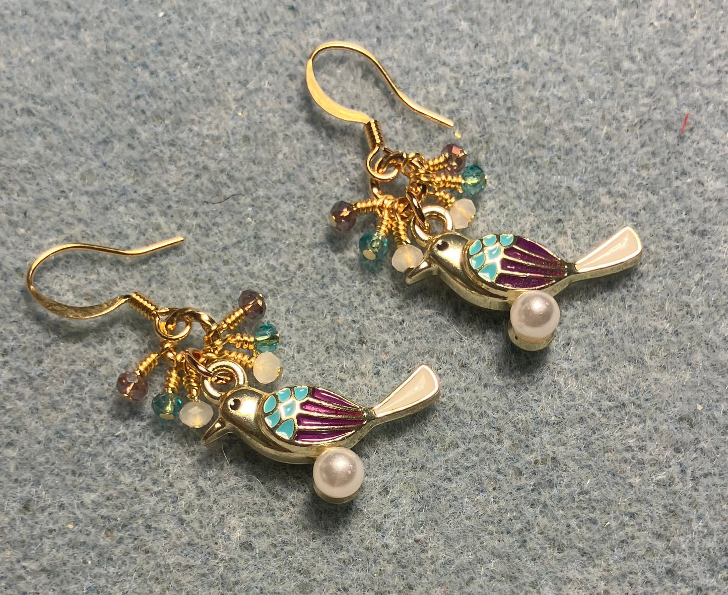 Violet, turquoise, and white enamel finch charm earrings adorned with tiny dangling violet, turquoise, and white Chinese crystal beads.