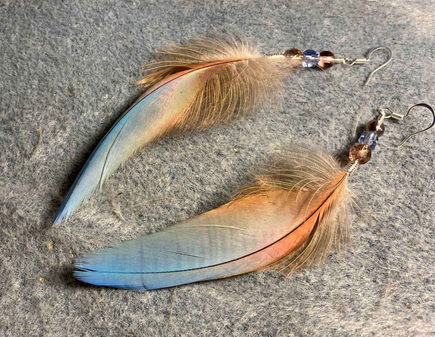 Light blue and peach scarlet macaw feather earrings adorned with rose pink and light blue Czech glass beads.