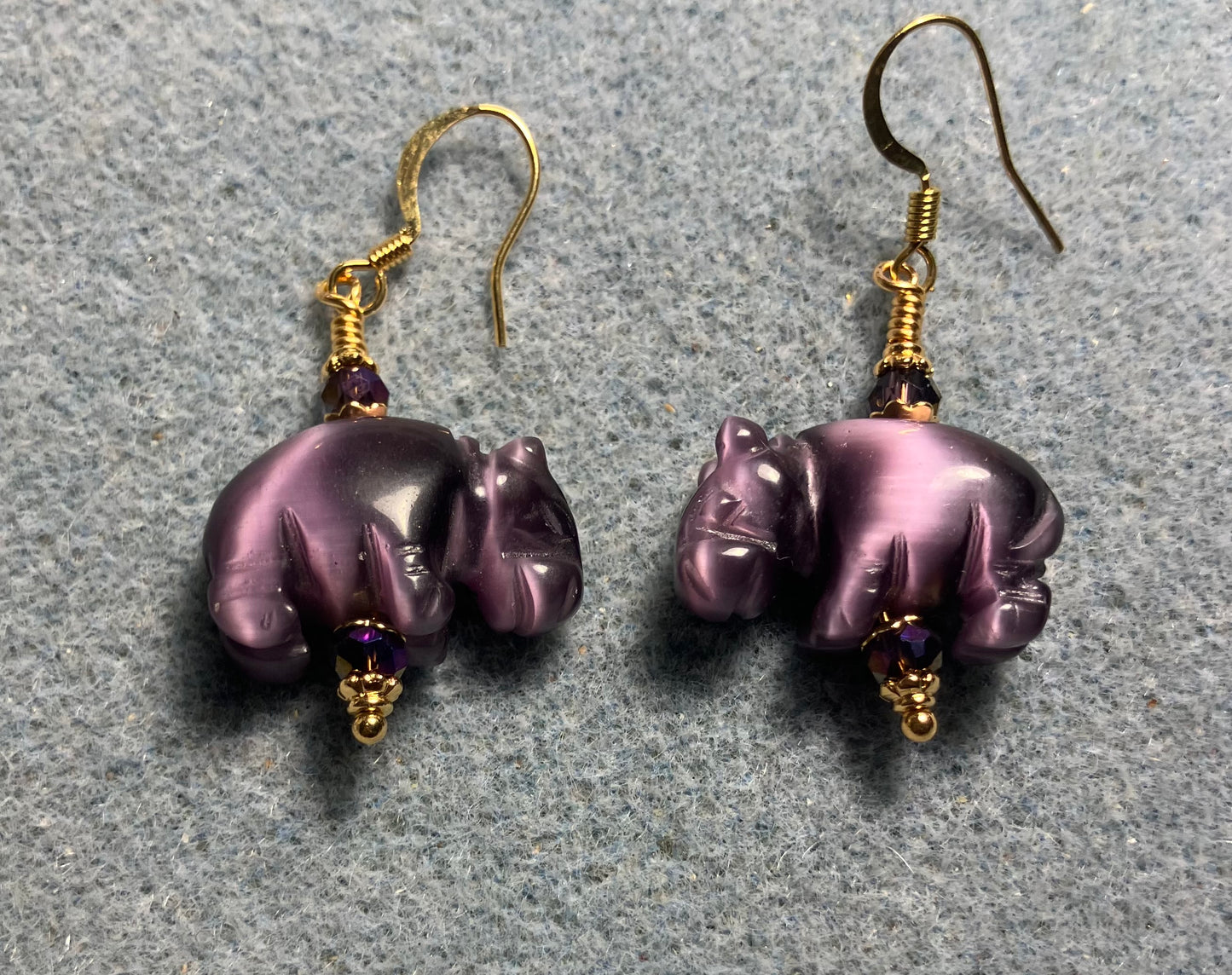 Purple fiber optic (cat’s eye)hippo bead earrings adorned with purple Chinese crystal beads.