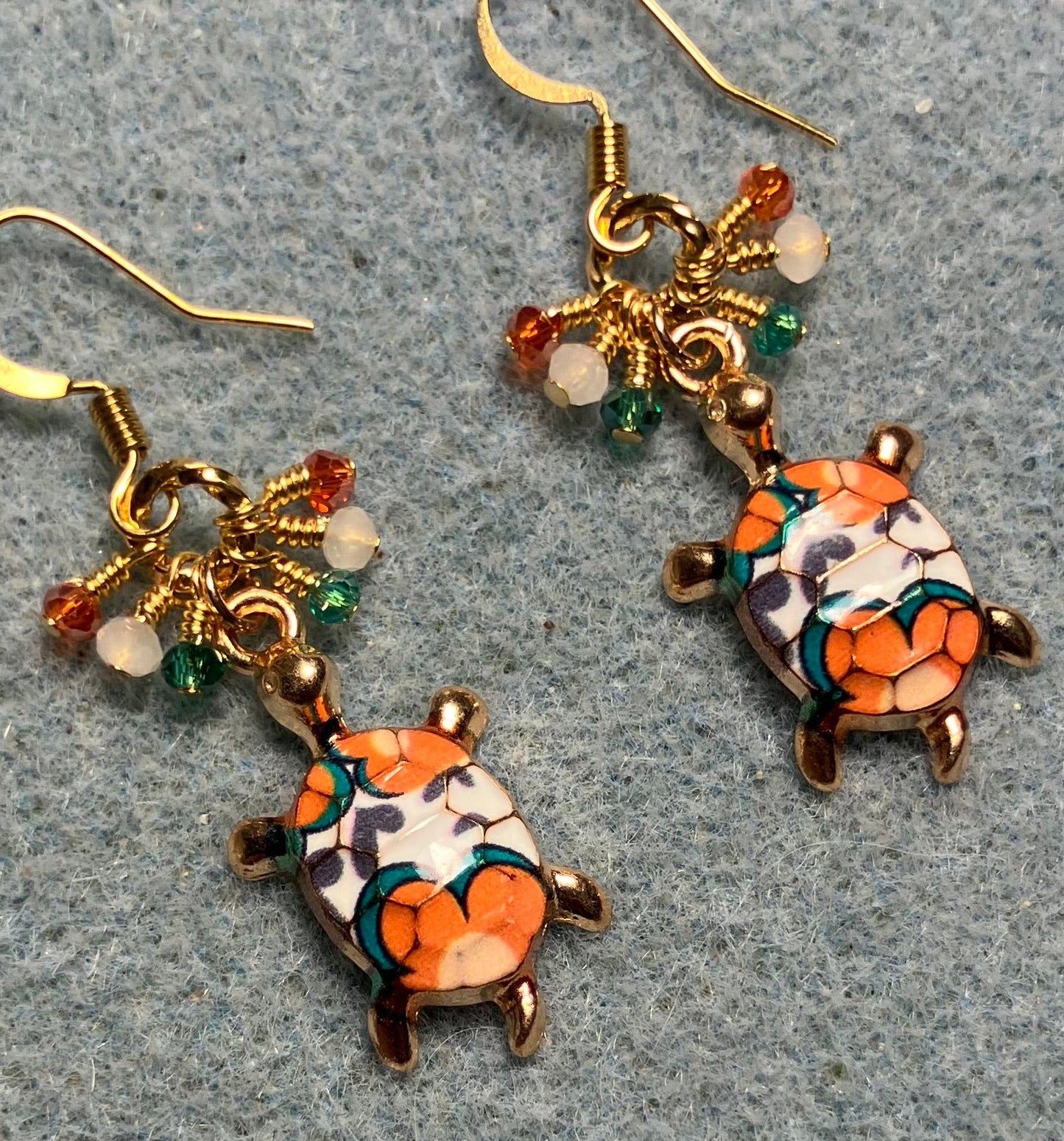 Orange, teal, and white enamel turtle charm earrings adorned with tiny dangling orange, teal, and white Chinese crystal beads.