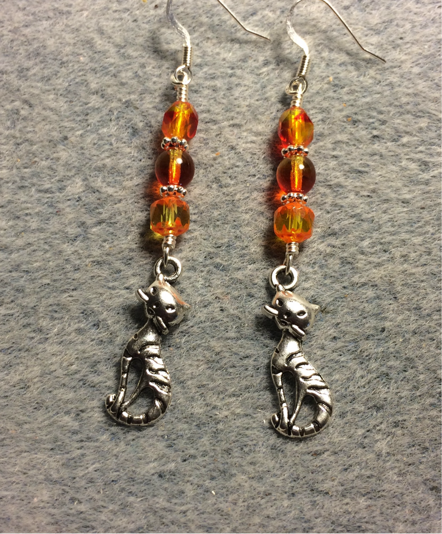 Silver cat charm earrings adorned with orange yellow Czech glass beads