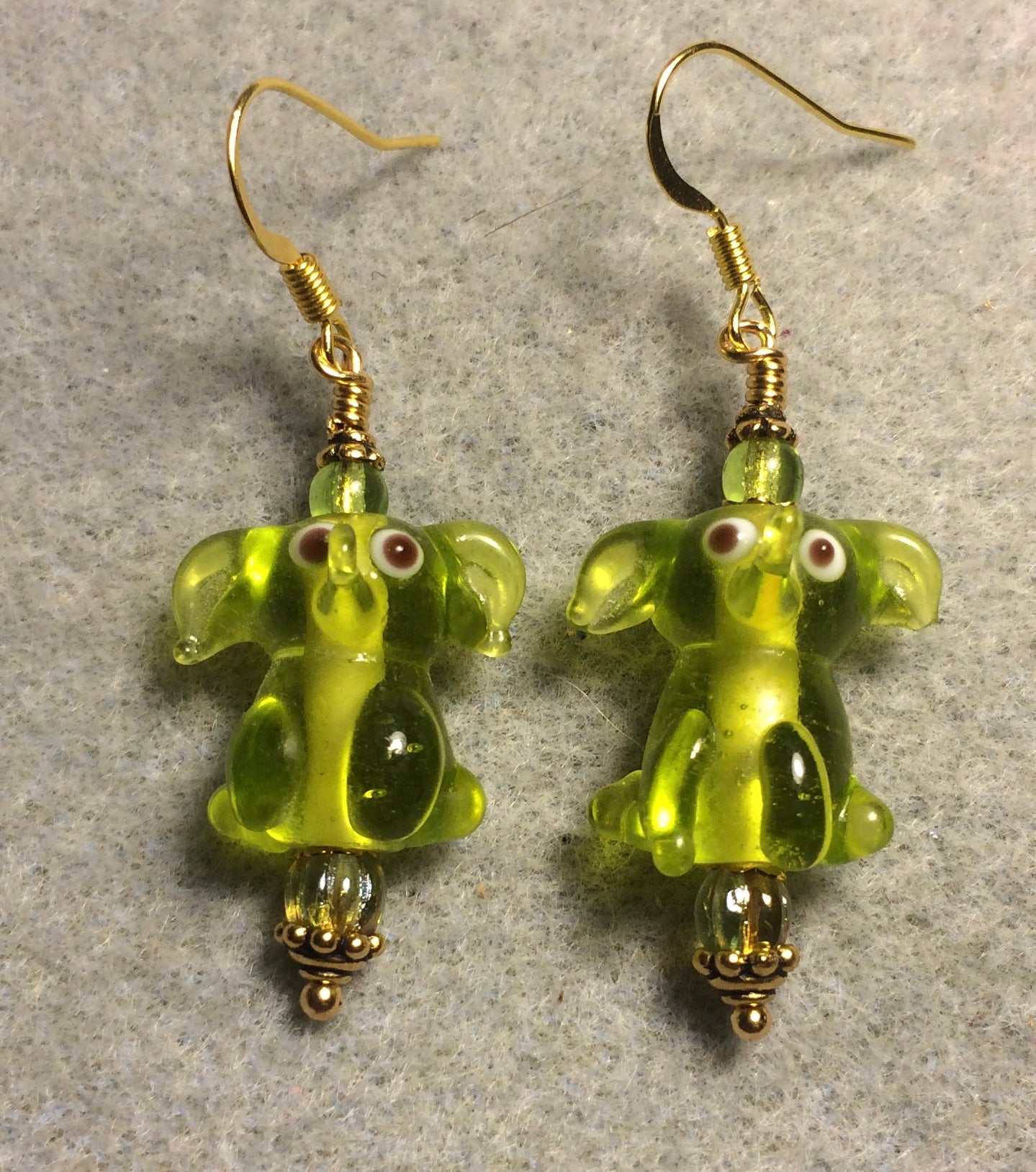 Translucent olive green lamp work sitting elephant bead earrings adorned with olive green Czech glass beads.