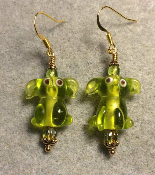 Translucent olive green lamp work sitting elephant bead earrings adorned with olive green Czech glass beads.