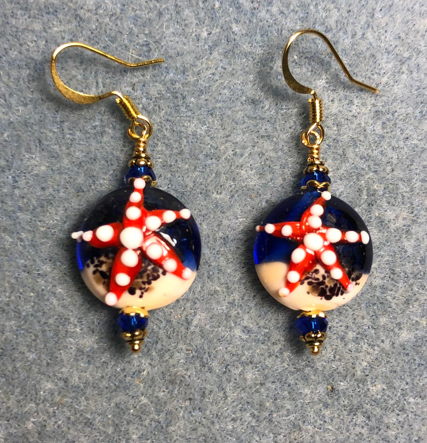 Dark blue, red, and tan lamp work starfish bead earrings adorned with dark blue Chinese crystal beads.