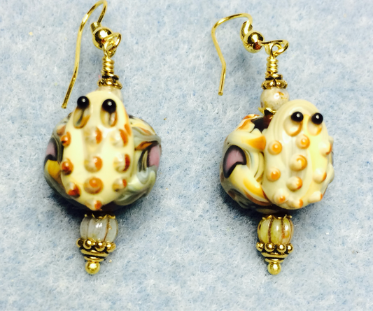 Black and tan lamp work frog bead earrings adorned with tan Czech glass beads.