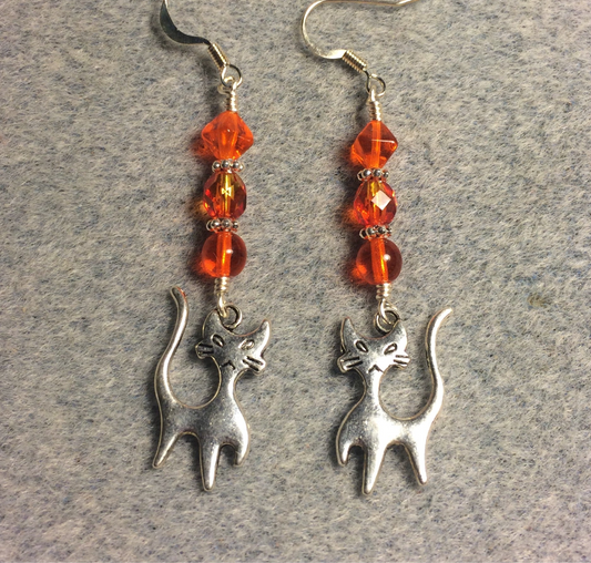 Silver cat charm earrings adorned with orange Czech glass beads