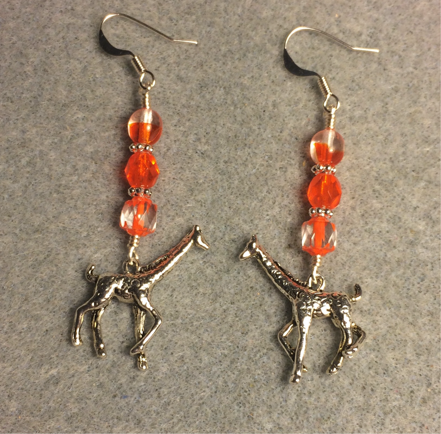 Silver giraffe charm earrings adorned with clear orange Czech glass beads