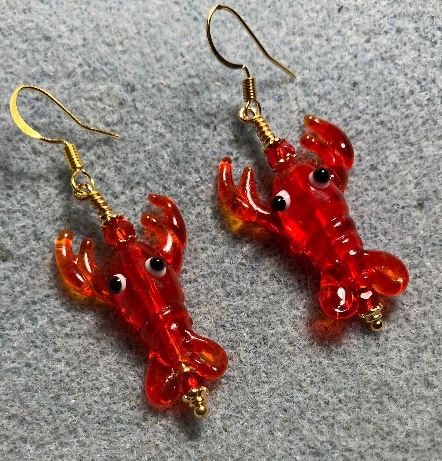 Red lamp work lobster bead earrings adorned with red Chinese crystal beads.