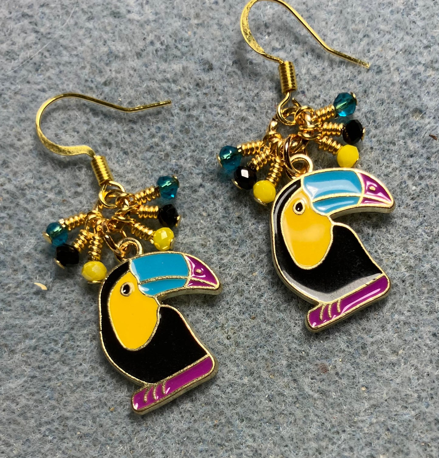 Black, yellow, turquoise, and rose enamel toucan charm earrings adorned with tiny dangling black, yellow, and turquoise Chinese crystal beads.