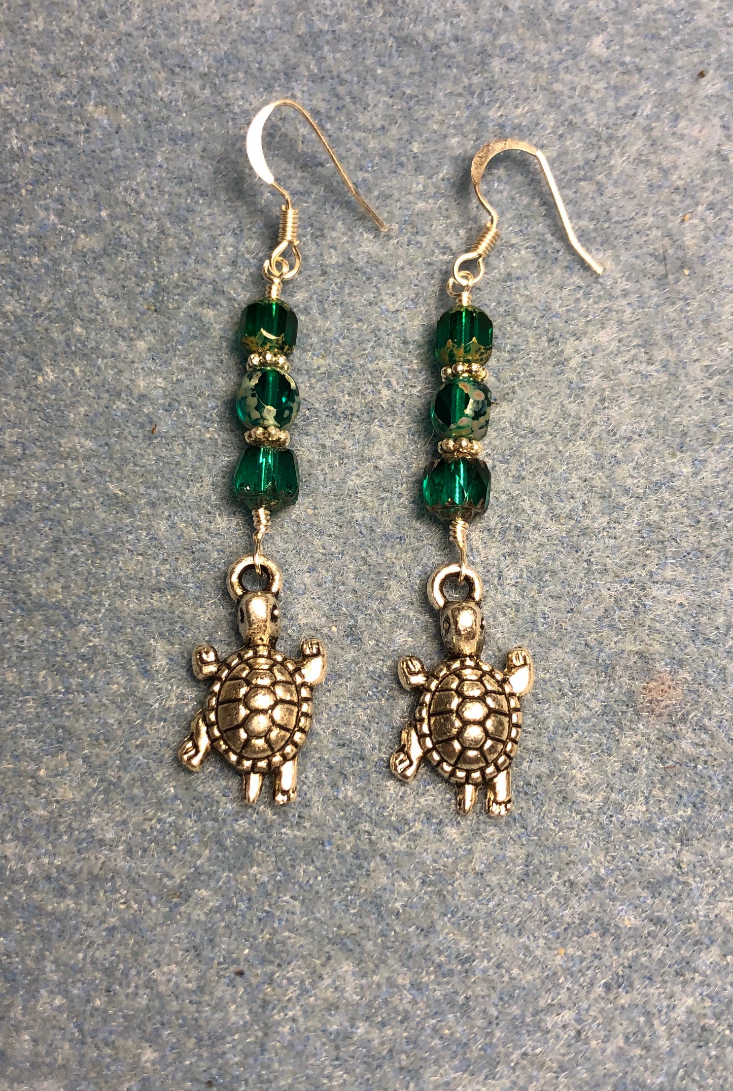 Silver tortoise charm earrings adorned with teal Czech glass beads