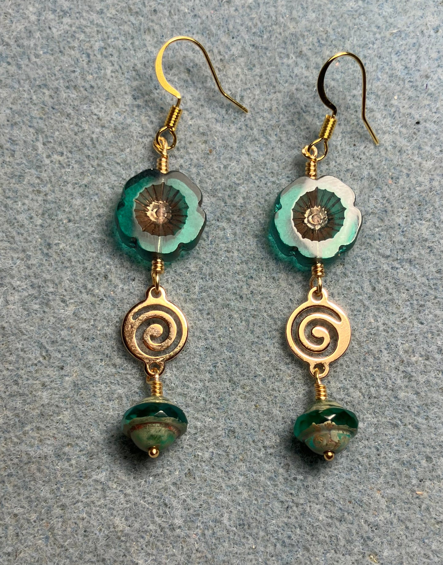 Translucent teal and gold Czech glass pansy bead earrings adorned with gold swirly connectors and teal Czech glass Saturn beads.