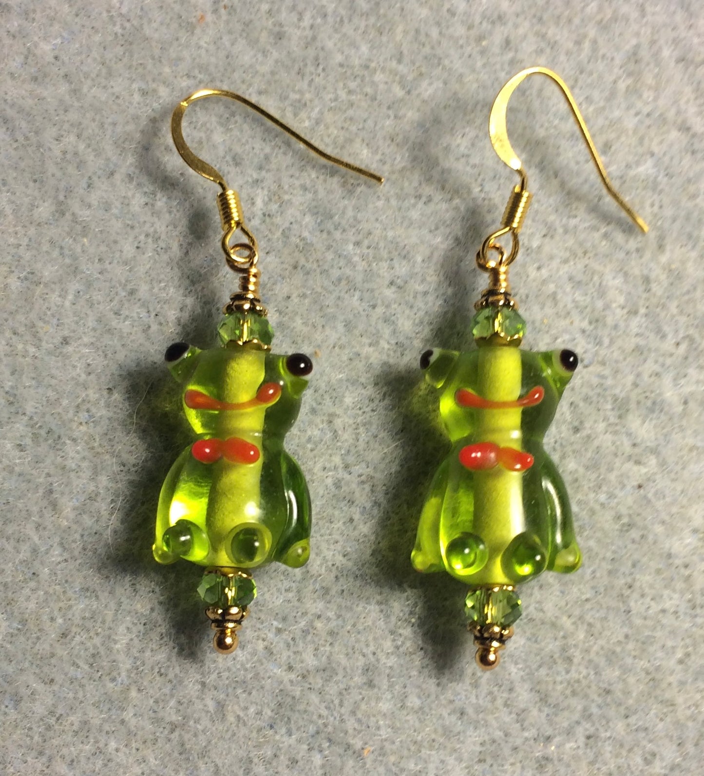 Translucent olive green lamp work silly frog bead earrings adorned with olive green Chinese crystal beads.