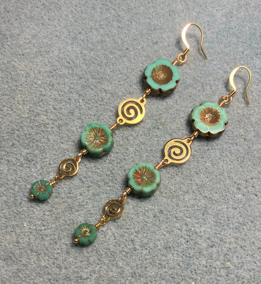 Extra long green and brown flower bead earrings made with three sizes of green and brown Czech glass pansy beads joined by gold swirly connectors.