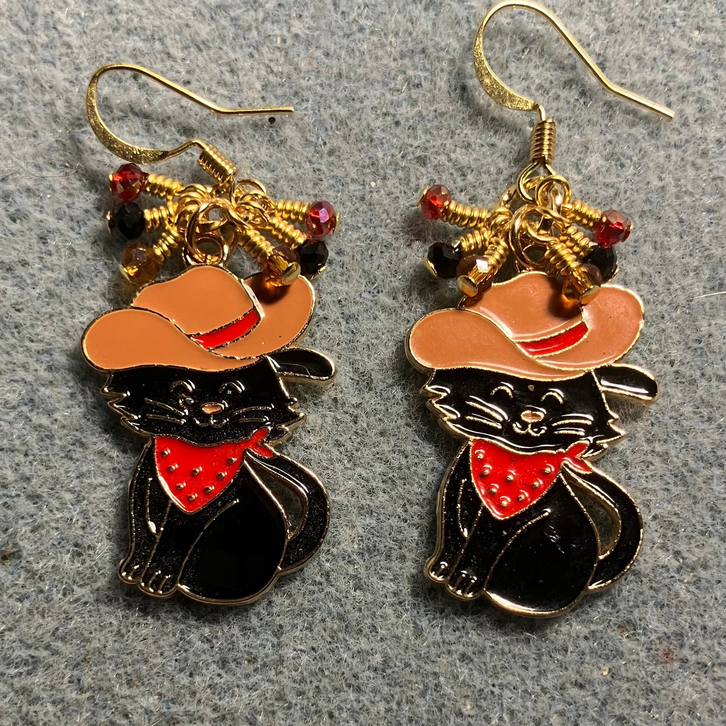 Black, brown, and red enamel cowboy cat charm earrings adorned with tiny dangling black, brown, and red Chinese crystal beads.