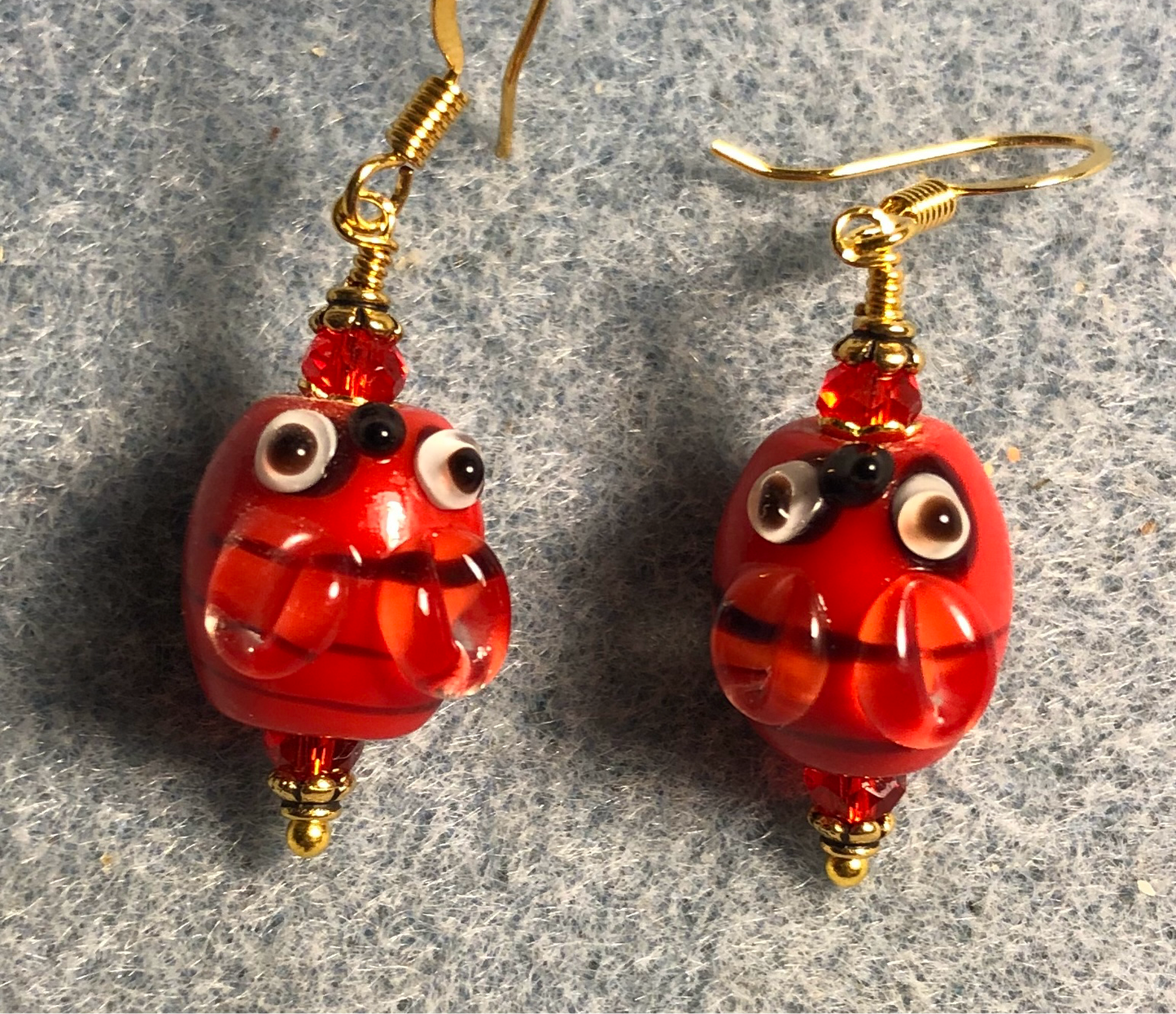 Red and black lamp work striped honeybee bead earrings adorned with red Chinese crystal beads.