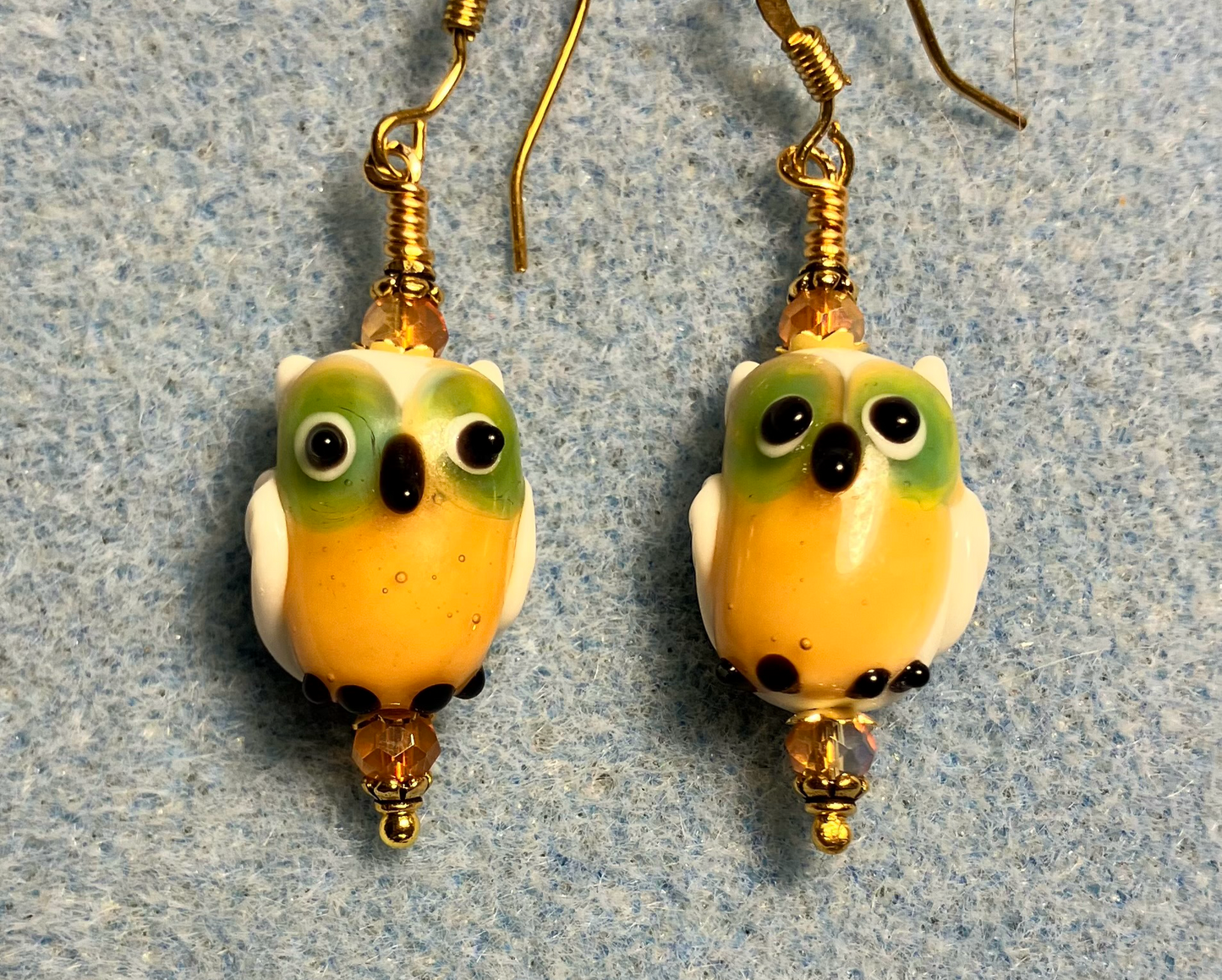 Orange lamp work owl bead earrings adorned with orange Chinese crystal beads.
