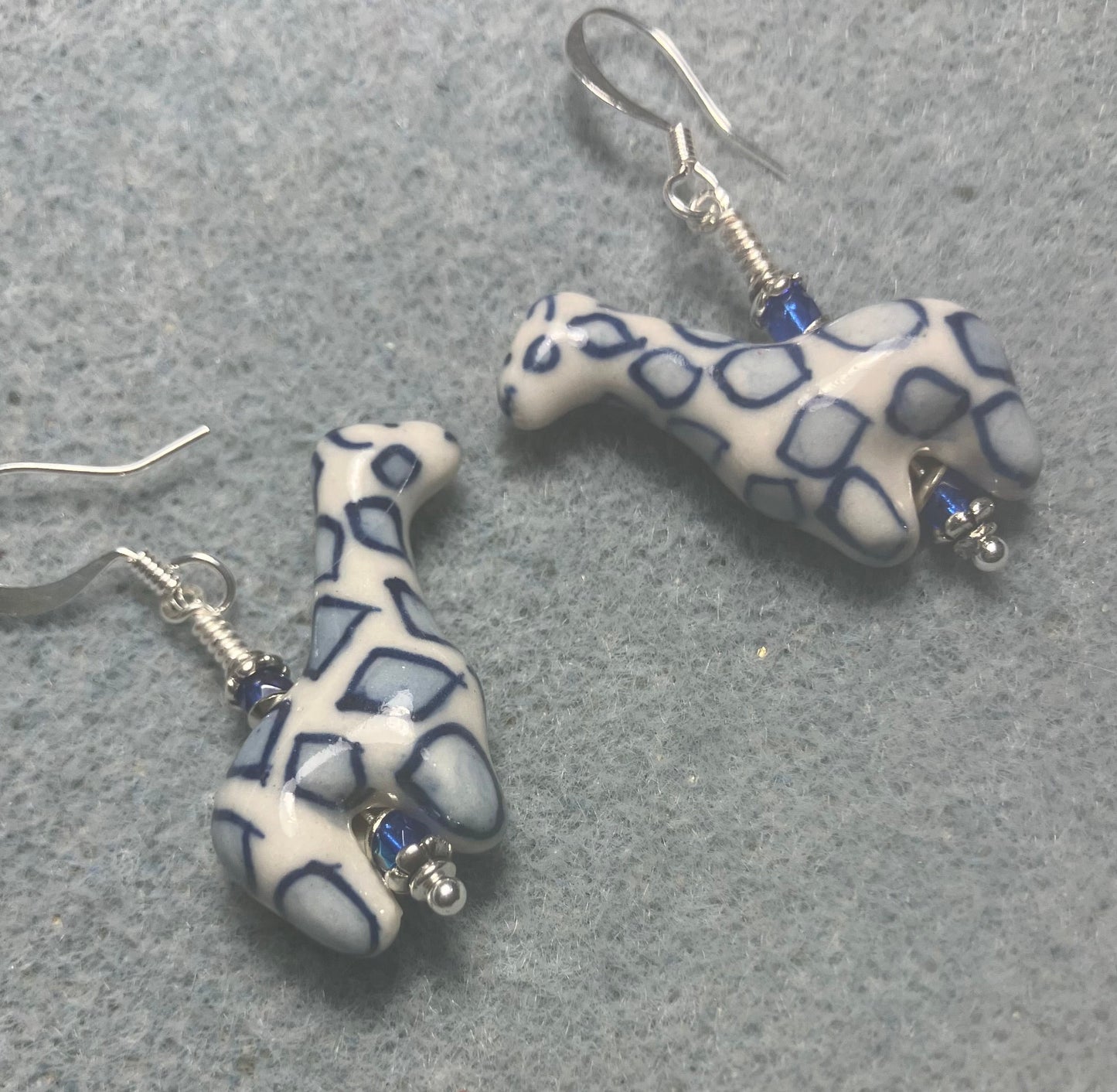 Dark blue and white ceramic spotted giraffe bead earrings adorned with small dark blue Czech glass beads.