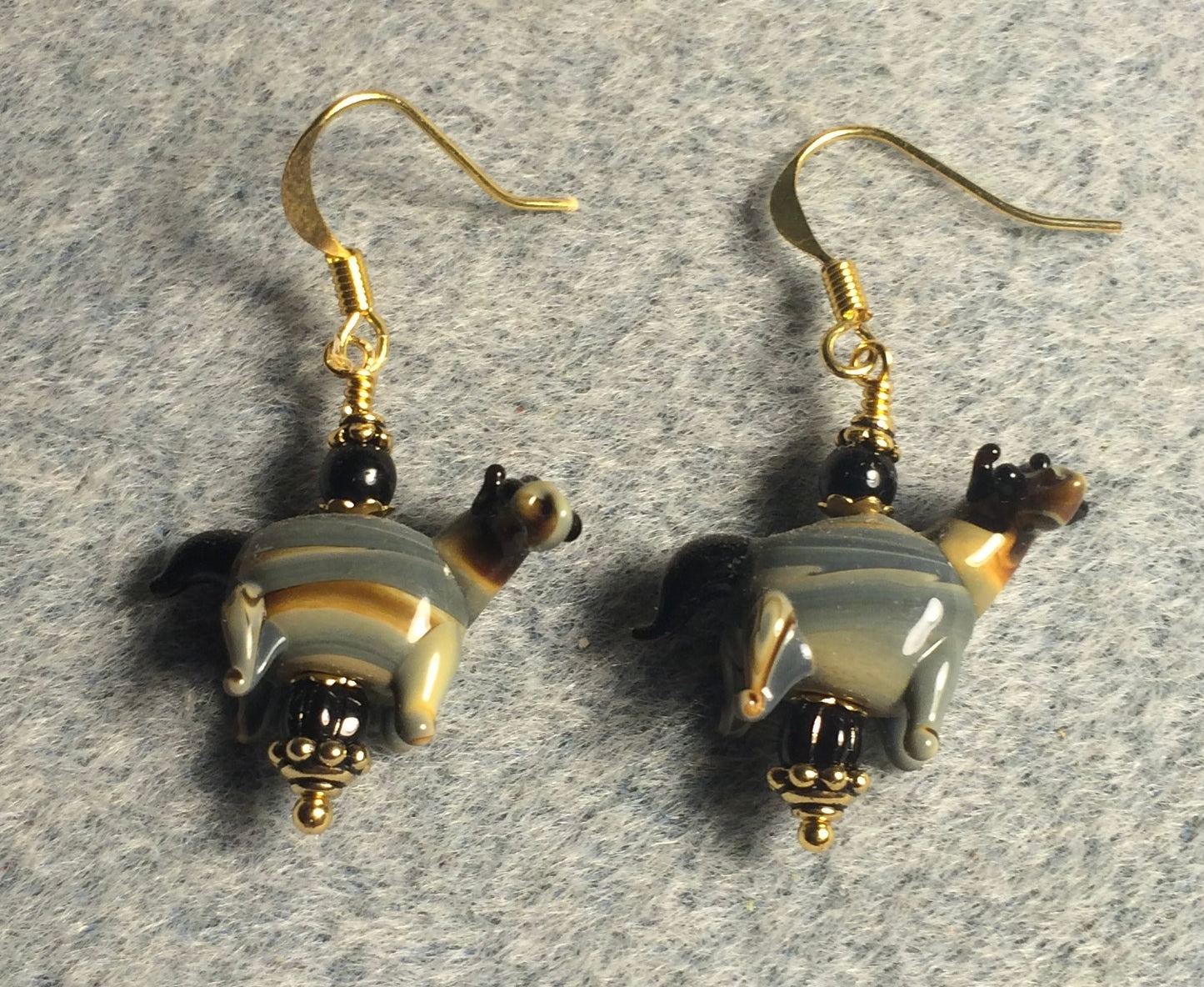 Black, tan, and gray lamp work striped horse bead earrings adorned with black Czech glass beads.