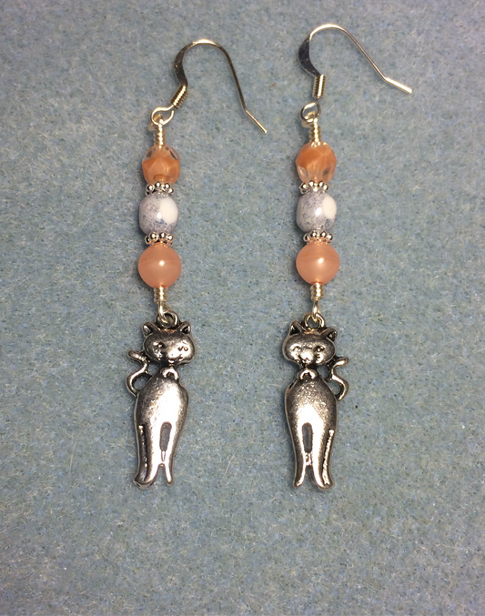 Silver cat charm earrings adorned with peach and white Czech glass beads.