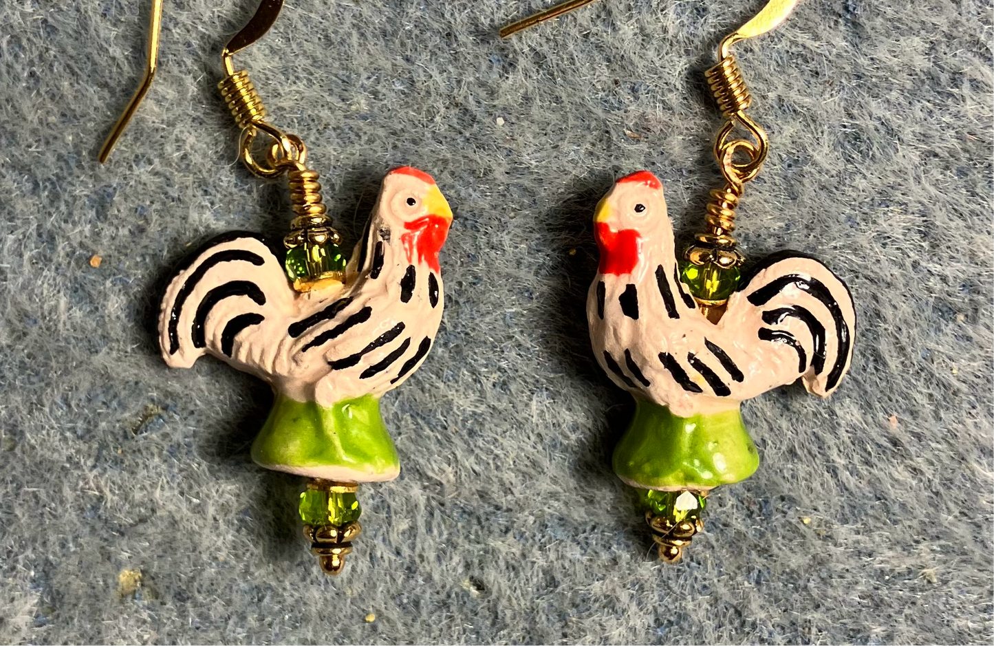 Small olive green, white, black, and red ceramic chicken bead earrings adorned with olive green Chinese crystal beads.