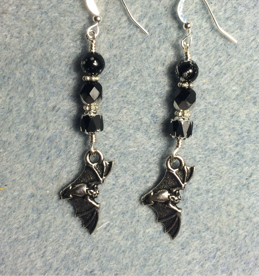 Silver flying bat charm earrings adorned with black Czech glass beads.