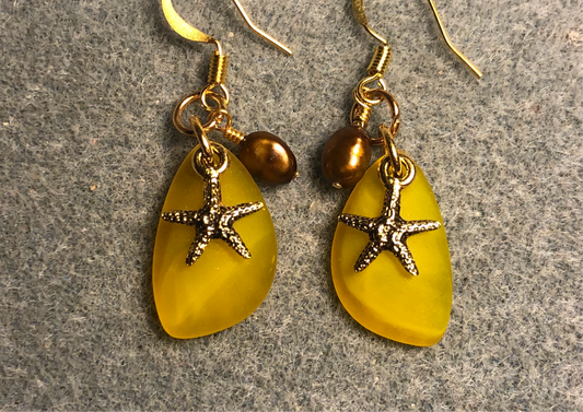 Small amber sea glass pendant bead earrings adorned with small gold starfish charms and small amber pearl beads.