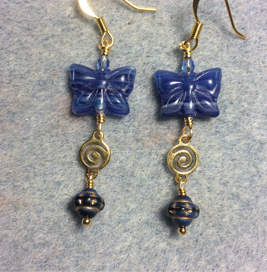 Dark blue Czech glass butterfly bead earrings adorned with gold swirly connectors and dark blue Czech glass Saturn beads.