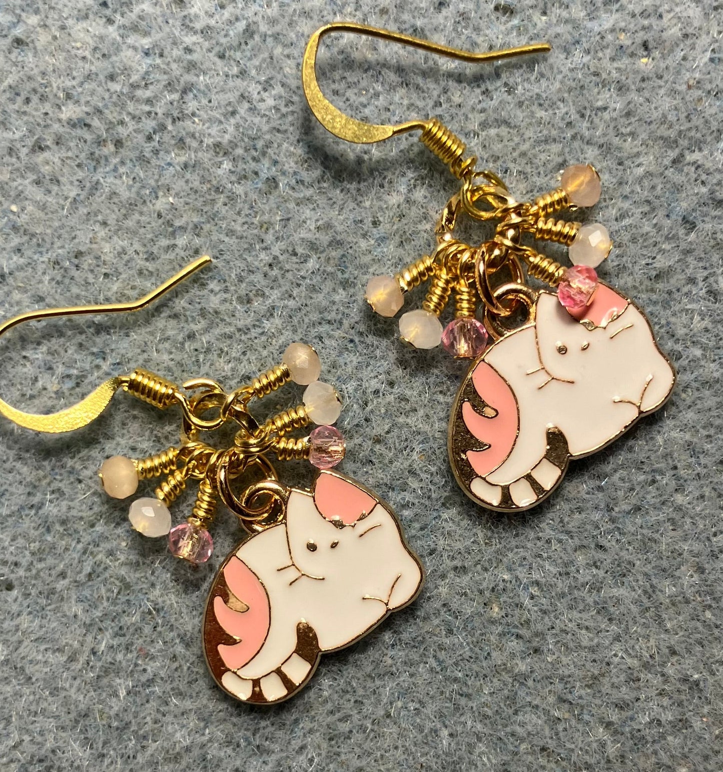 Small pink and white enamel cat charm earrings adorned with tiny dangling pink and white Chinese crystal beads.