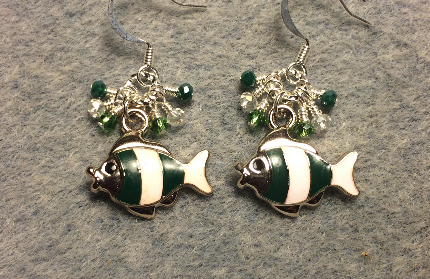 Dark green and white enamel striped fish charm earrings adorned with tiny dangling dark green and clear Chinese crystal beads.