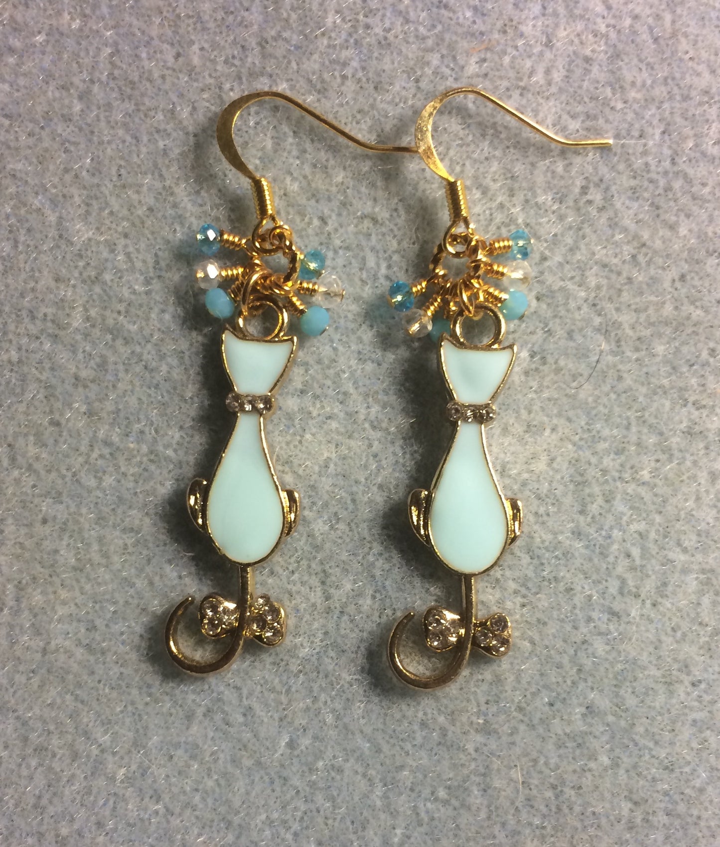 Aqua and gold enamel cat charm earrings adorned with tiny dangling aqua, clear, and turquoise Chinese crystal beads.