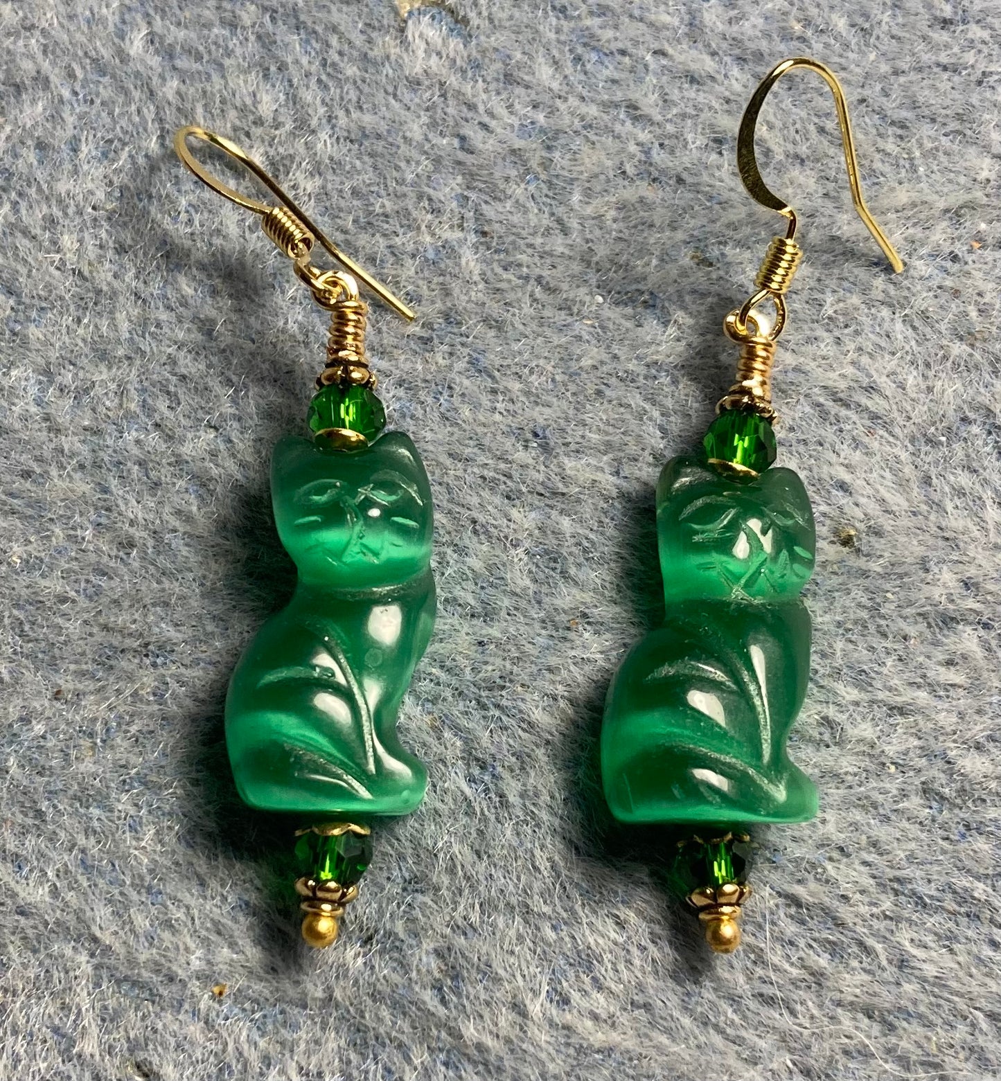 Emerald green fiber optic (cat’s eye) cat bead earrings adorned with emerald green Chinese crystal beads.