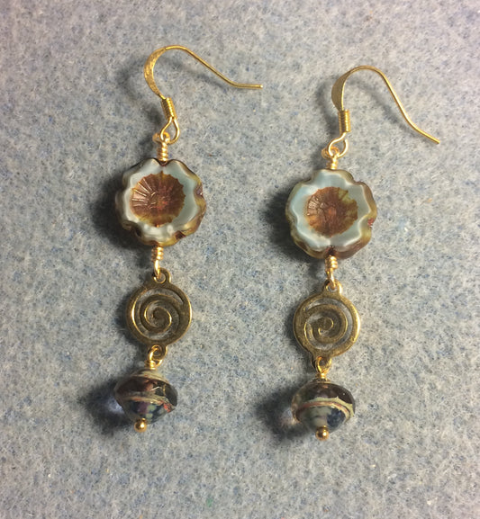 Light blue and brown Czech glass pansy bead earrings adorned with gold swirly connectors and light blue Czech glass Saturn beads.