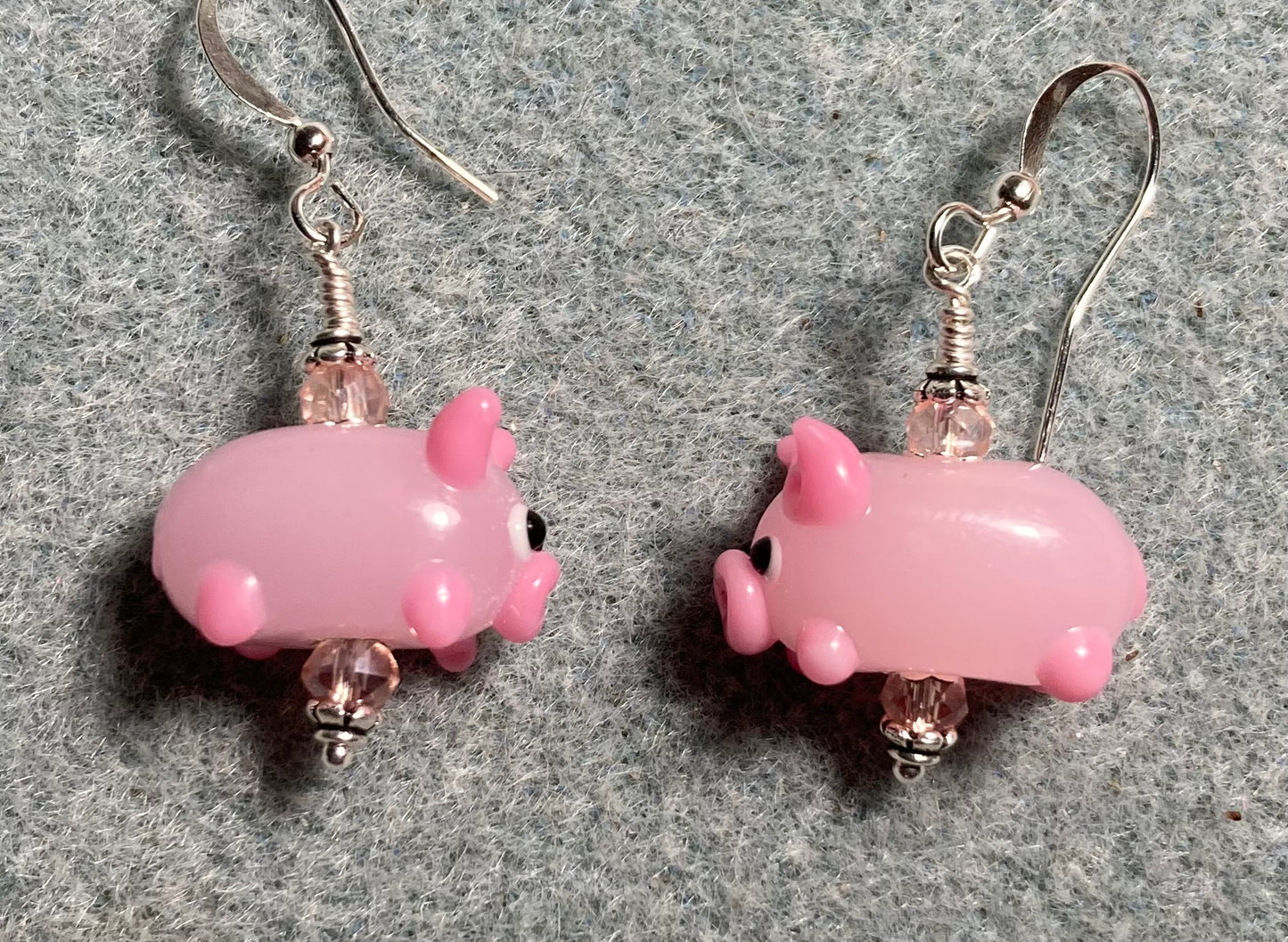 Light pink lamp work pig bead earrings adorned with pink Chinese crystal beads.