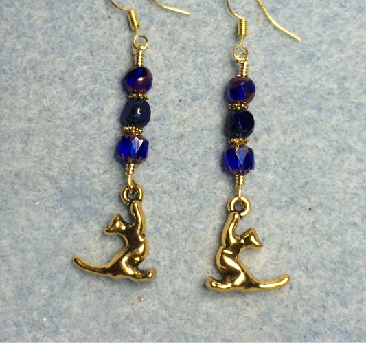 Gold stretching cat charm earrings adorned with dark blue Czech glass beads