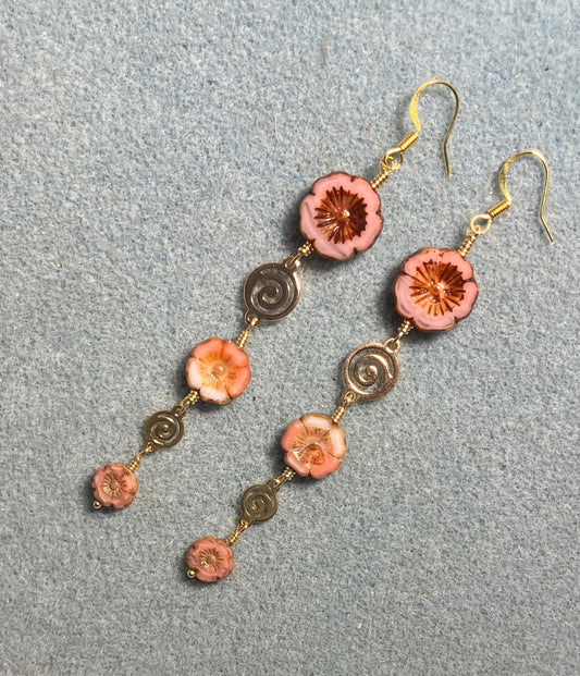 Extra long pink flower bead earrings made with three sizes of pink and white swirl Czech glass pansy beads joined by gold swirly connectors.