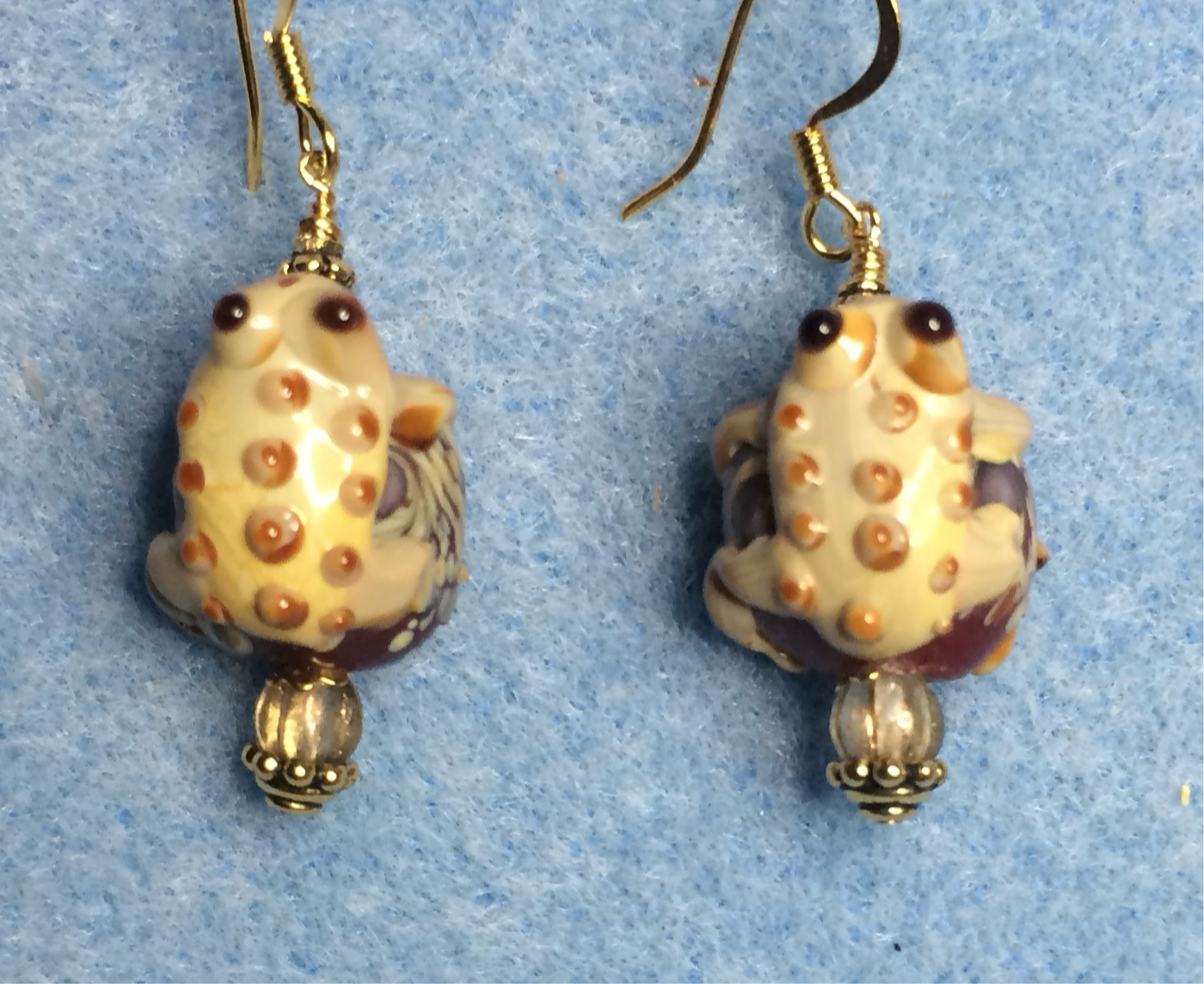 Dark red and tan lamp work frog bead earrings adorned with tan Czech glass beads.