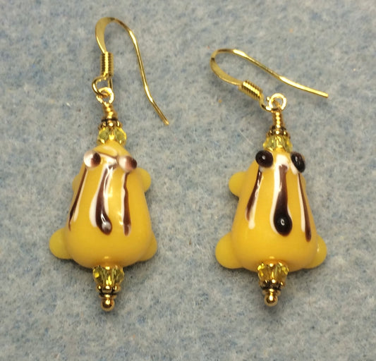 Yellow with black stripes lamp work frog bead earrings adorned with yellow Chinese crystal beads.