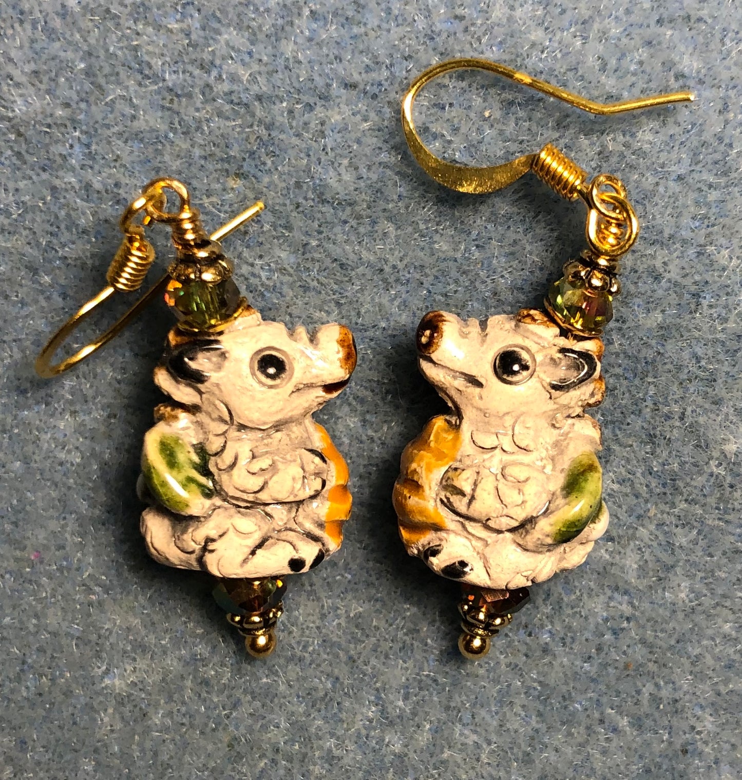 Small beige, green, and yellow ceramic alligator bead earrings adorned with sparkly olive green Chinese crystal beads.