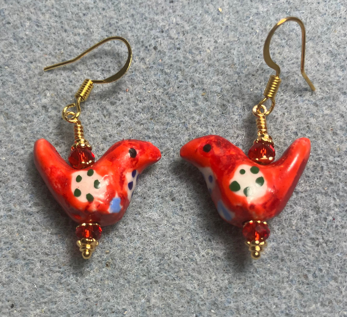 Small red, white, and black ceramic bird bead earrings adorned with red Chinese crystal beads.