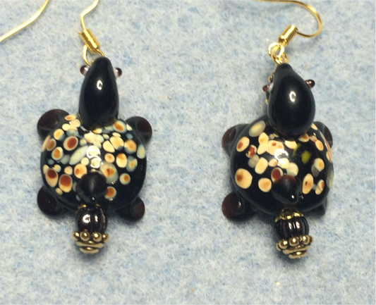 Opaque black lamp work spotted turtle bead earrings adorned with black Czech glass beads.