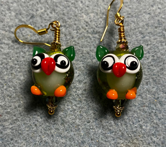 Olive green, orange, and red lamp work owl bead earrings adorned with olive green Chinese crystal beads.