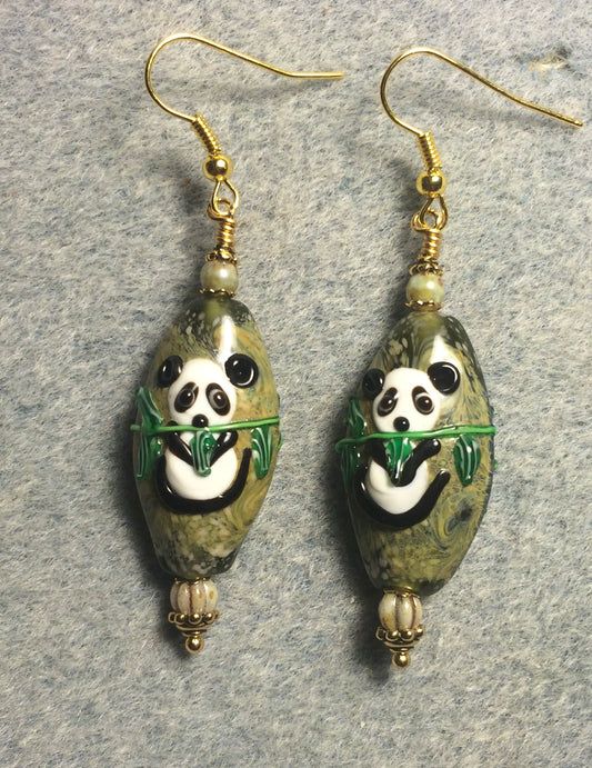 Oval tan, green, and black lamp work panda bear bead earrings adorned with tan Czech glass beads.