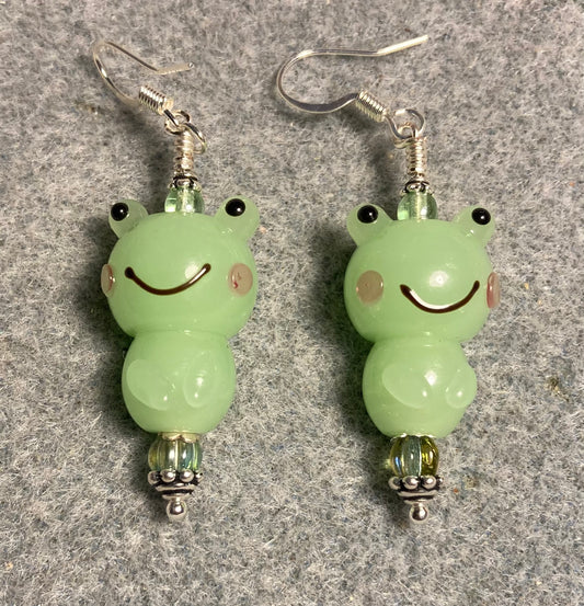 Opaque light green lamp work frog bead earrings adorned with light green Czech glass beads.