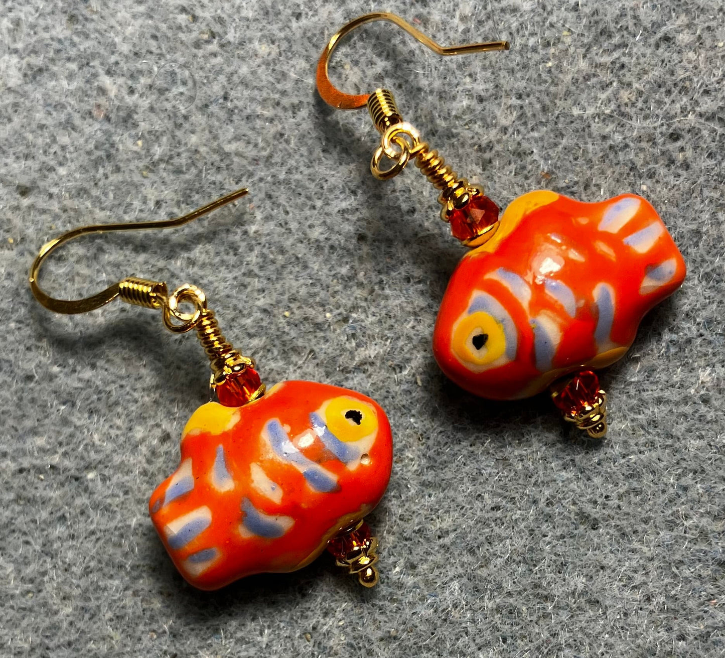Orange, blue, and yellow ceramic spotted fish bead earrings adorned with orange Chinese crystal beads.
