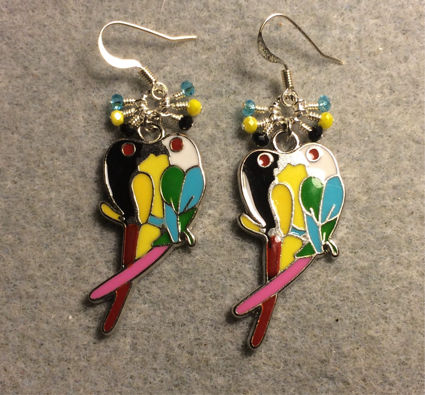 Black, yellow, and turquoise parrot charm earrings adorned with small dangling black, yellow, and turquoise Czech glass beads.